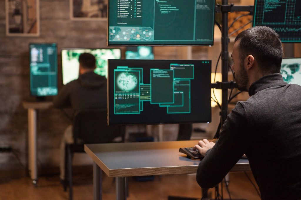 back view of hackers working on making a dangerous malware